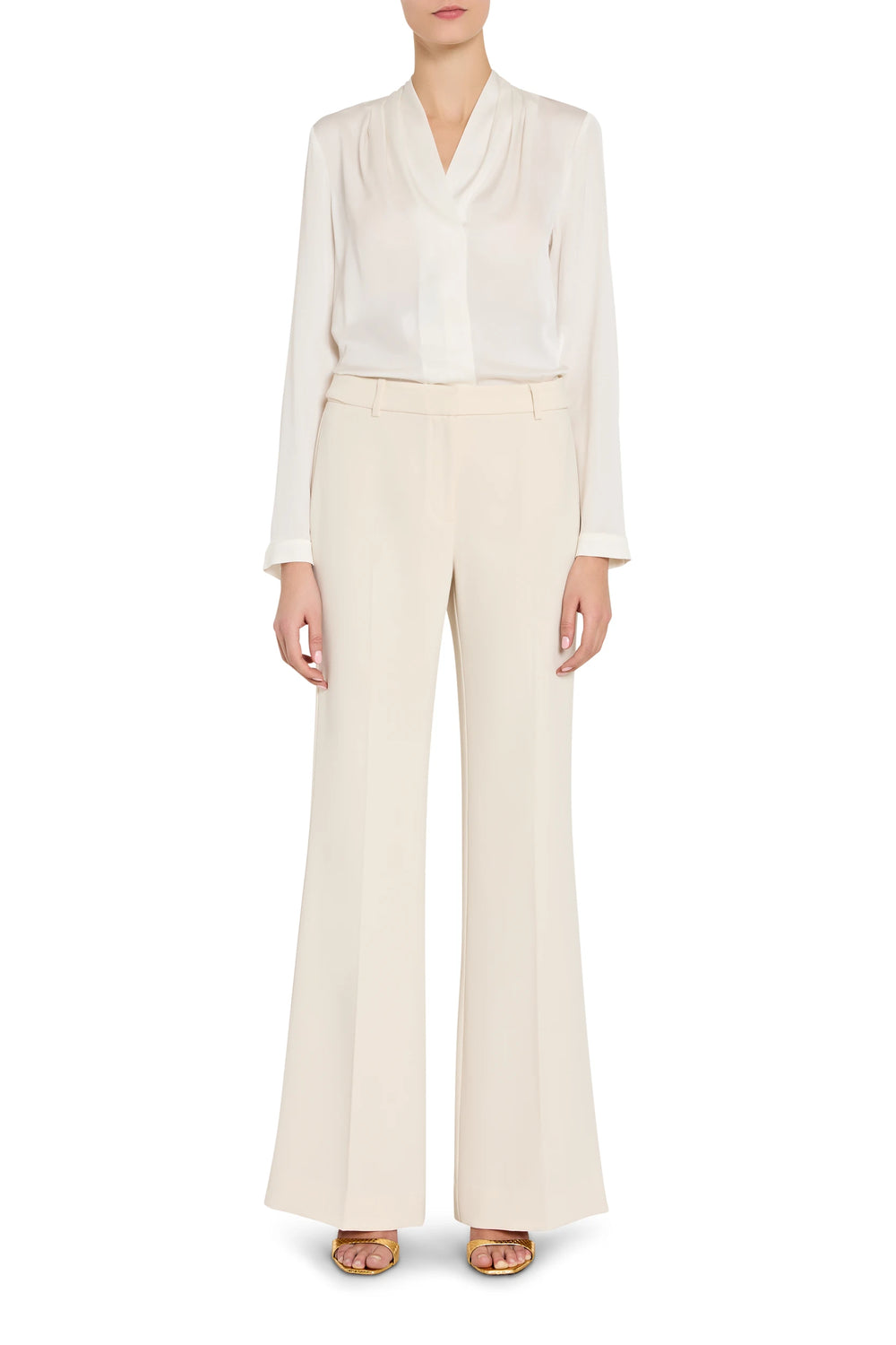 Person wearing a white blouse and beige pants on a white background