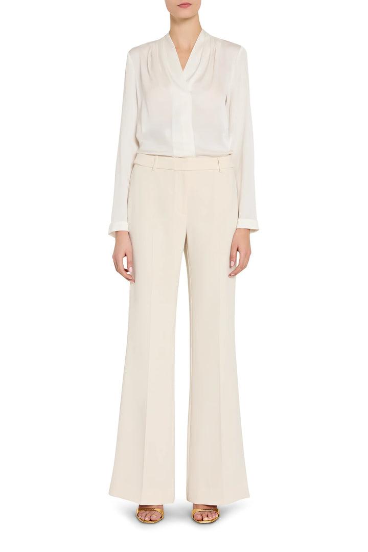Person wearing a white blouse and beige pants on a white background