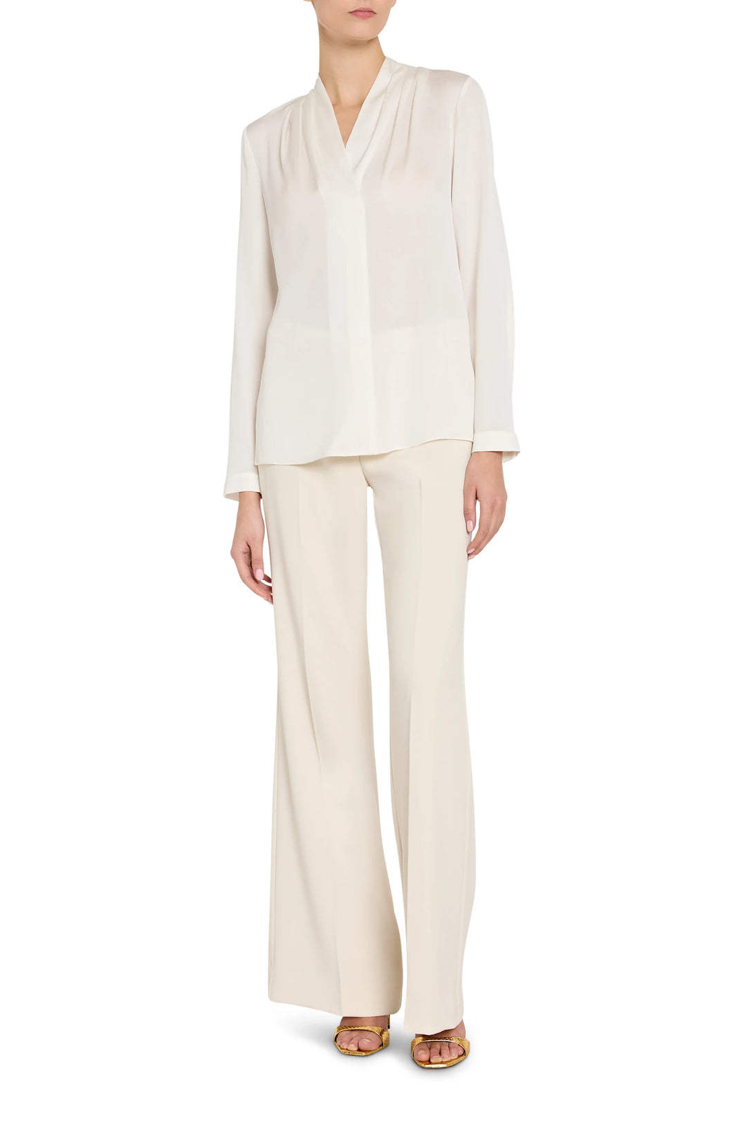 Person wearing a white blouse and pants on a white background