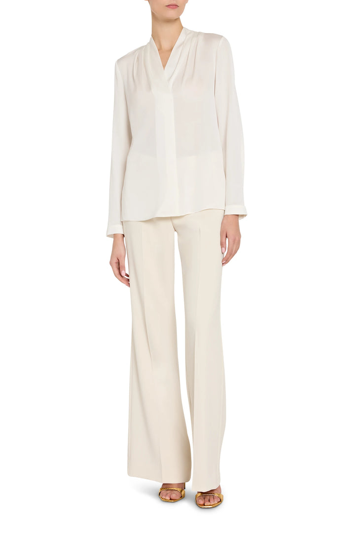Person wearing a white blouse and pants on a white background