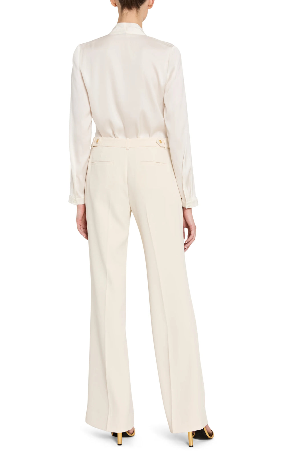 Person wearing a white blouse and cream pants on a white background