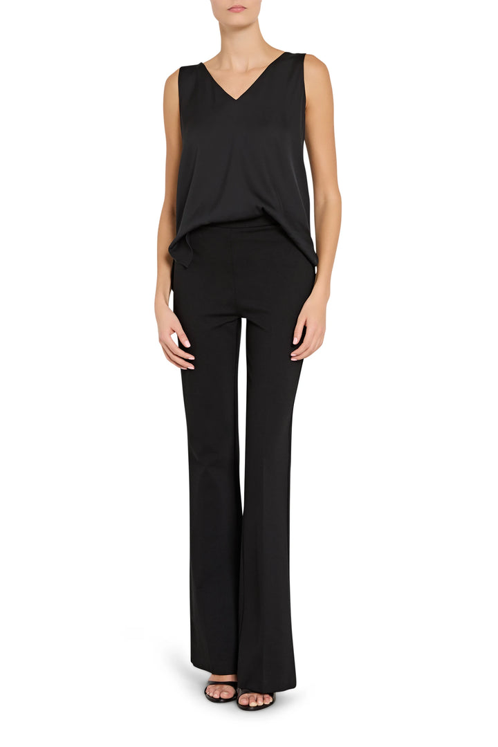 Woman wearing a black sleeveless top and wide-leg pants on a white background