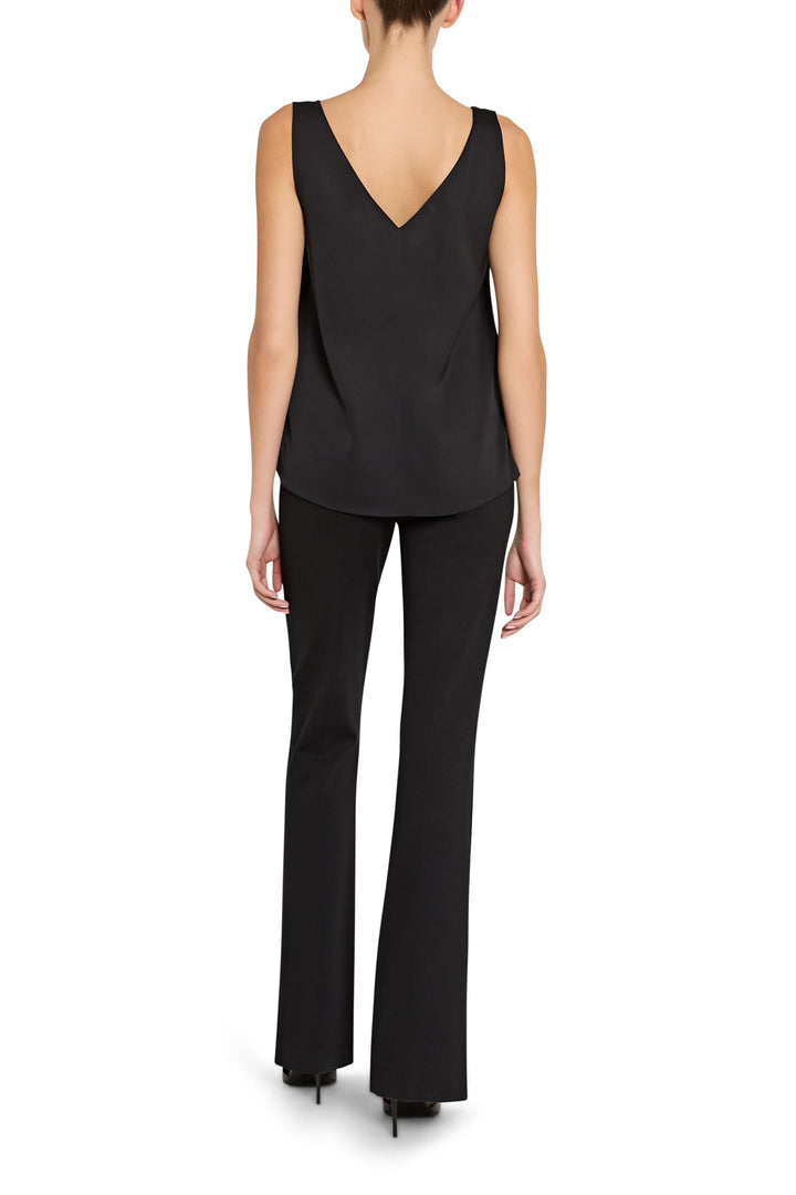 Person wearing a black sleeveless top and black pants on a white background