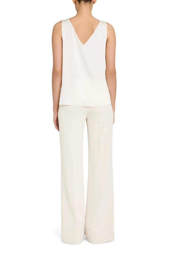Sleeveless silk blouse, V-neck, clean lines and draped silhouette. Front view on model.