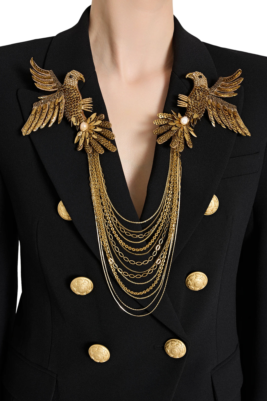 Black blazer with gold eagle designs and jewelry on a white background