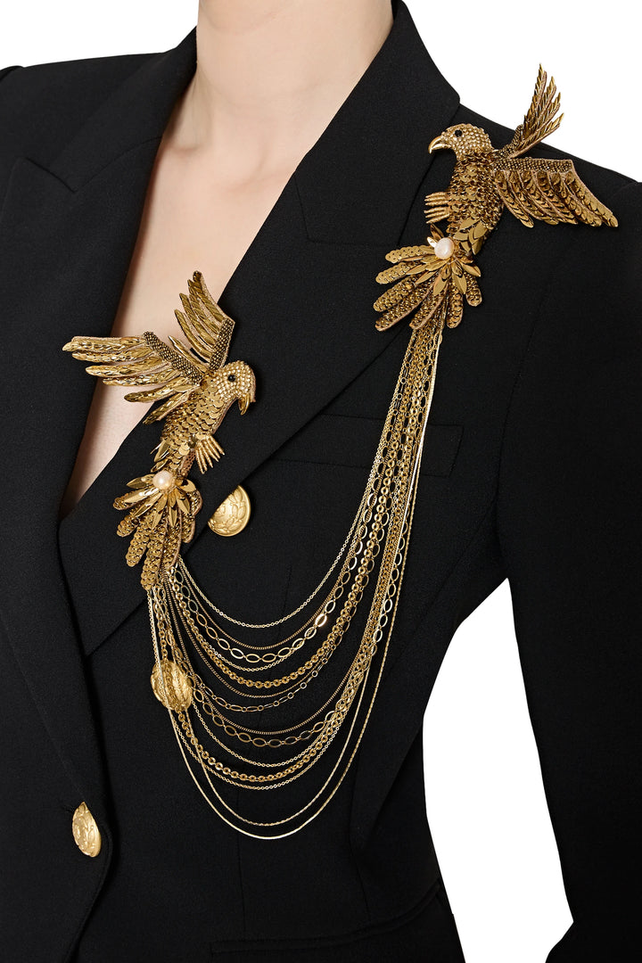 Black blazer with gold bird and chain detail on a white background