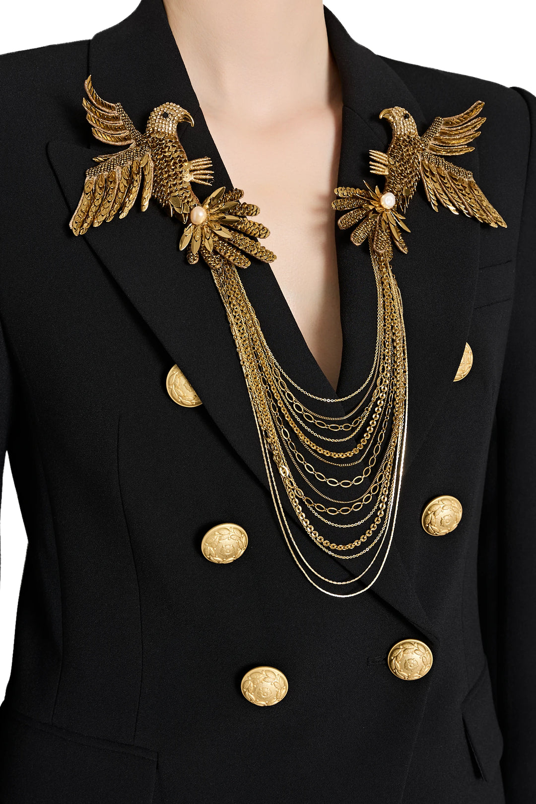 Black blazer with gold eagle brooches and necklace on a white background