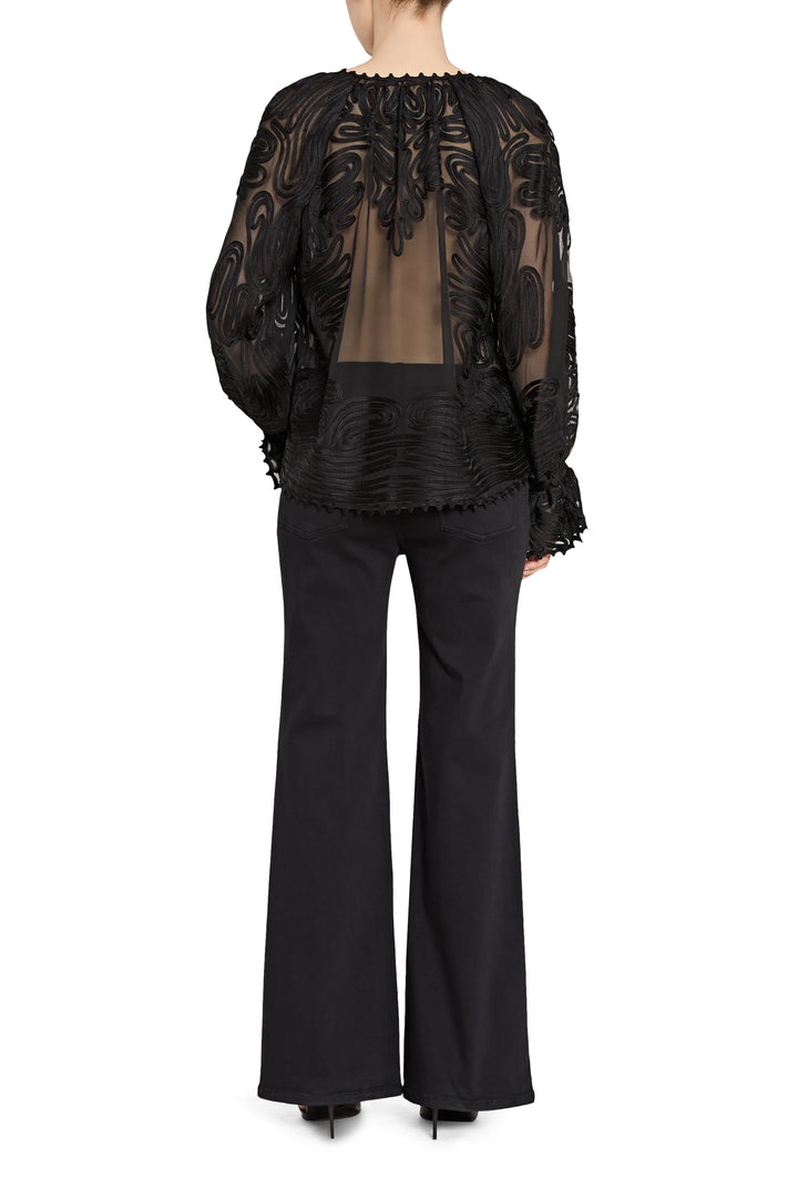 Black lace top and flared pants on a white background