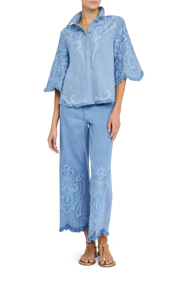 Embroidered denim blouse with relaxed fit, long sleeves, and button front; frayed hem. Front view on white.