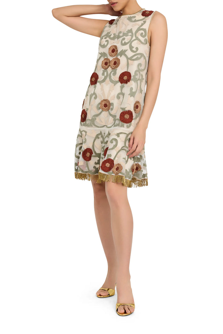 Mini dress with sleeveless organza silhouette, floral appliqué, and gold fringe hem. Front view on white.