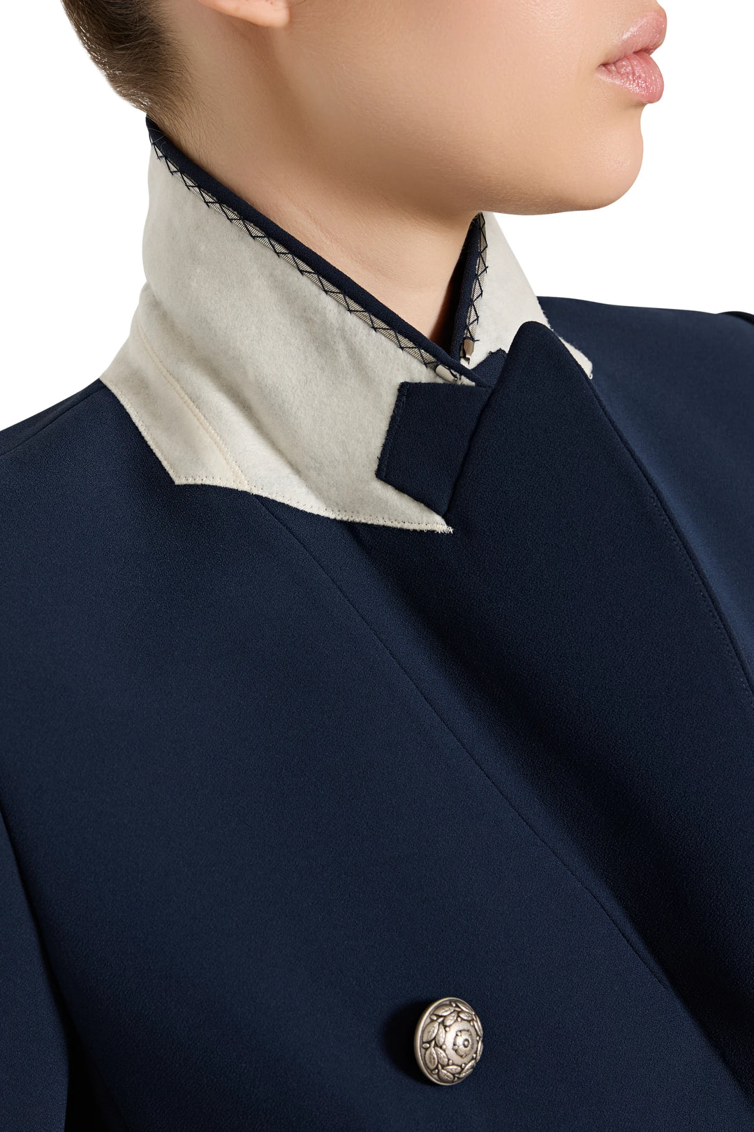 Navy blue coat with a decorative button on a white background