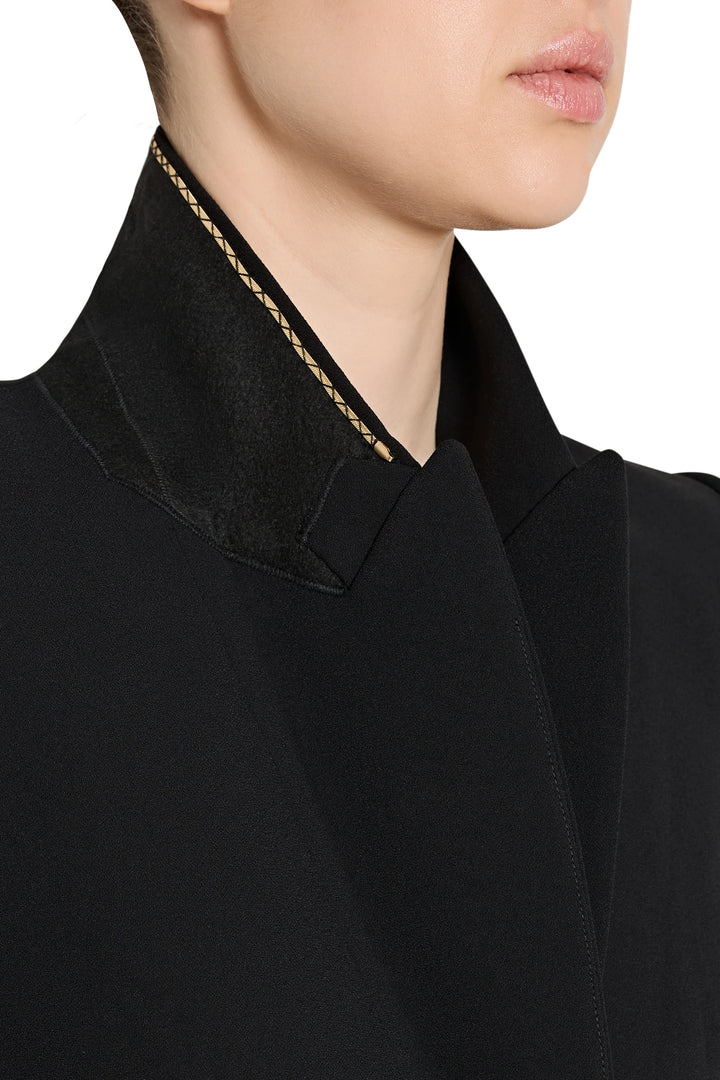Close-up of a black garment with a textured trim on a white background