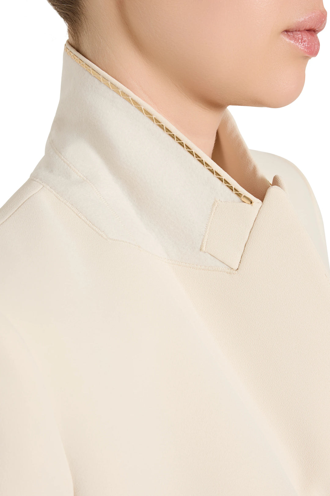 Close-up of a beige shirt with a decorative collar against a white background