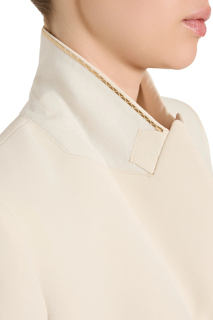 Close-up of a beige shirt with a decorative collar against a white background