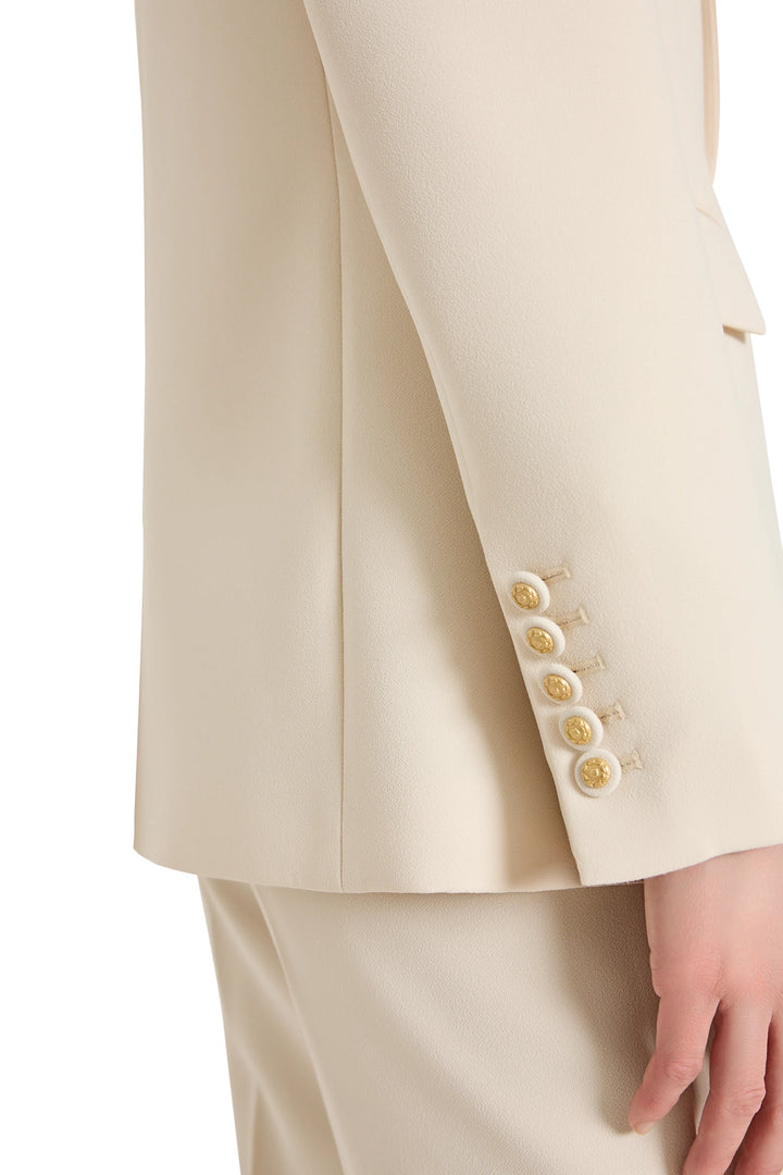 Beige suit jacket with gold buttons on a white background