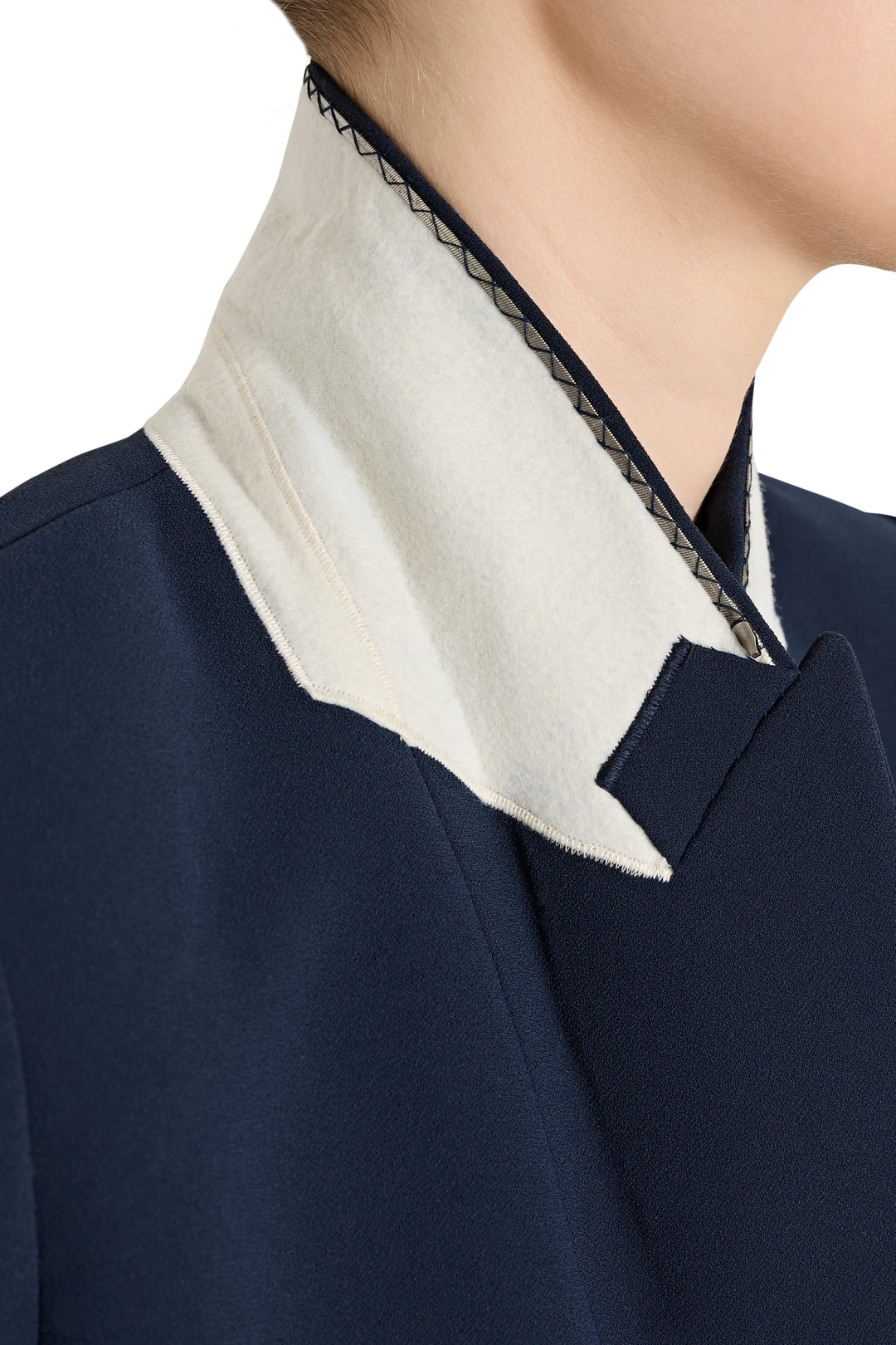Close-up of a navy blue garment with a white collar and black trim.