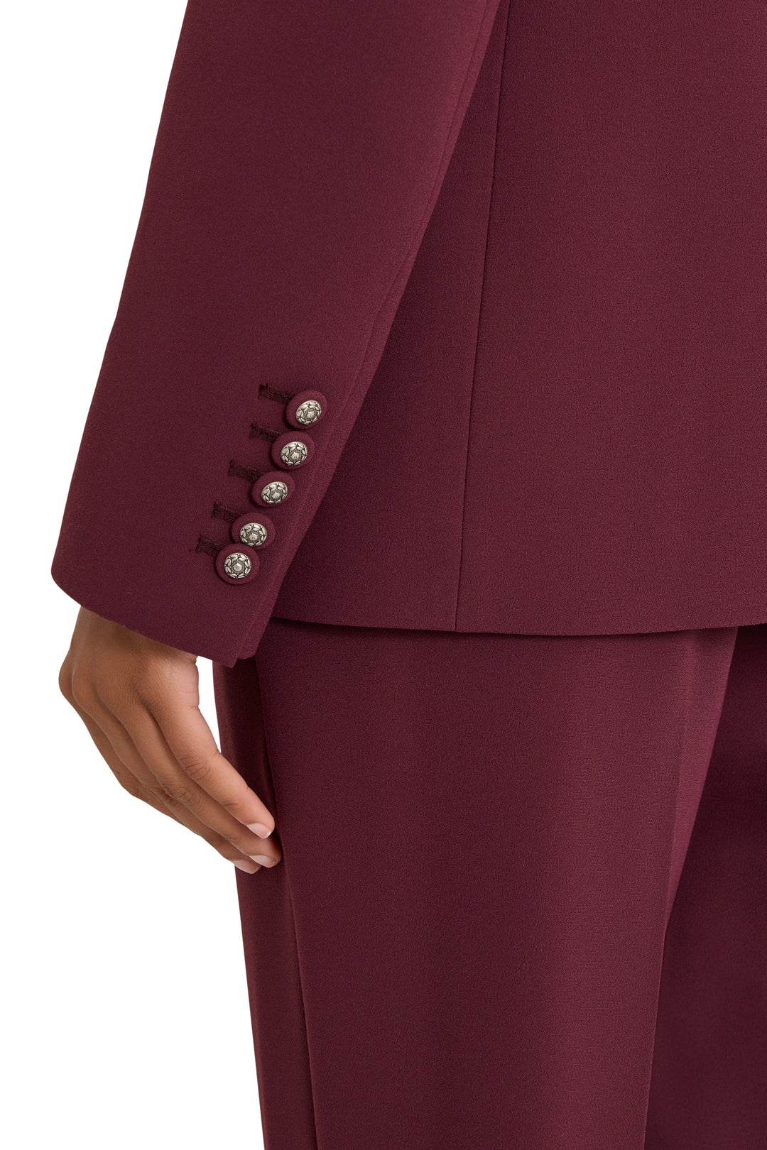 Tailored crepe blazer with structured shoulders, notched lapels, and button cuffs; front view on model.