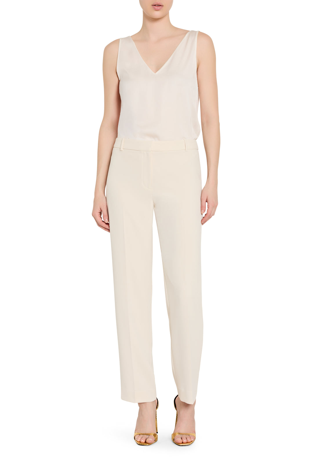 Person wearing a white sleeveless top and pants on a white background