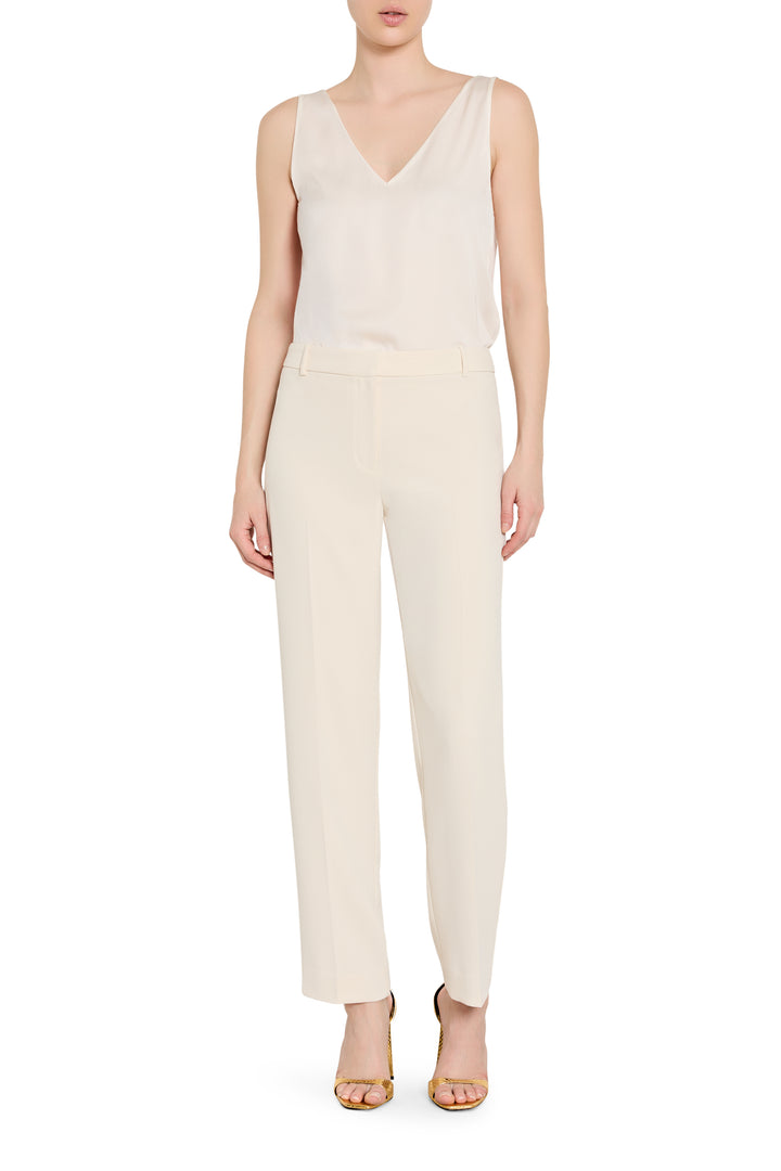 Person wearing a white sleeveless top and pants on a white background