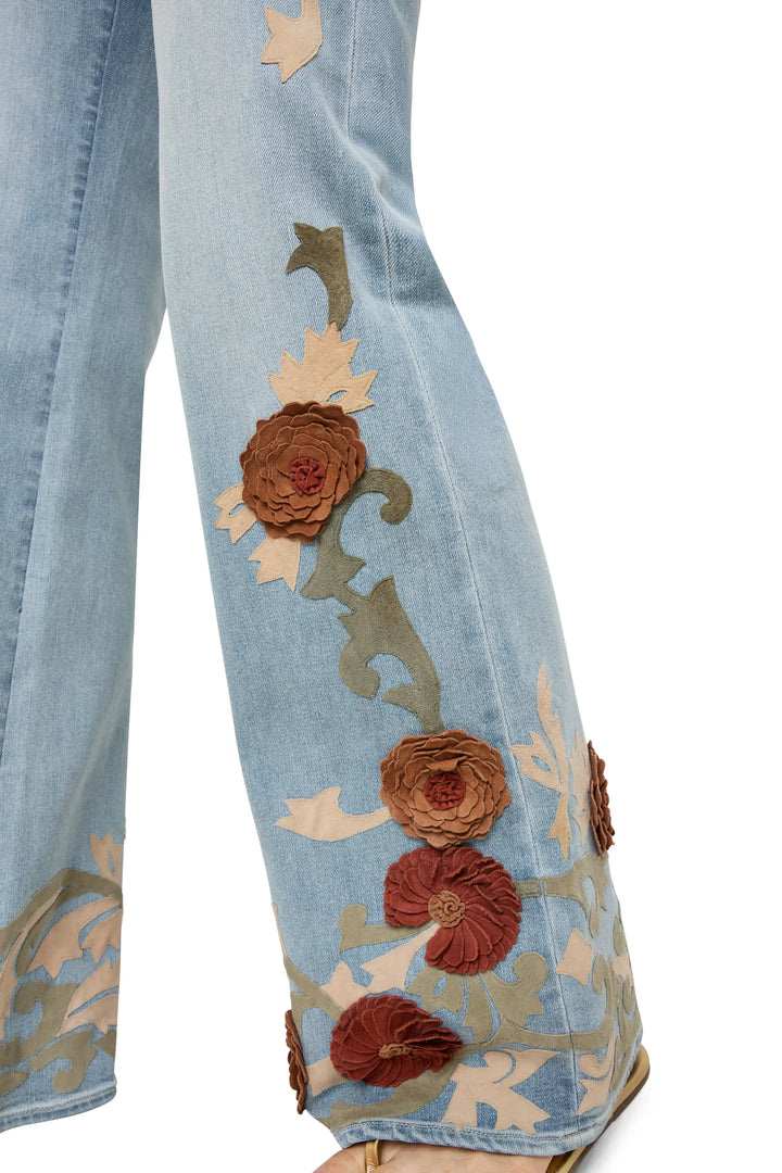 Low-rise, straight-leg denim with vintage wash and hand-embroidered details at leg and hem; front view on white.