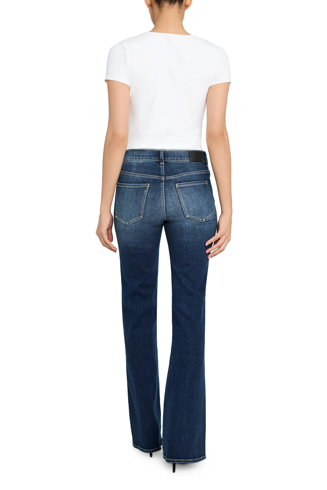 Low-rise denim flared jeans with classic five-pocket construction, fitted through hip and thigh. Back view on model.
