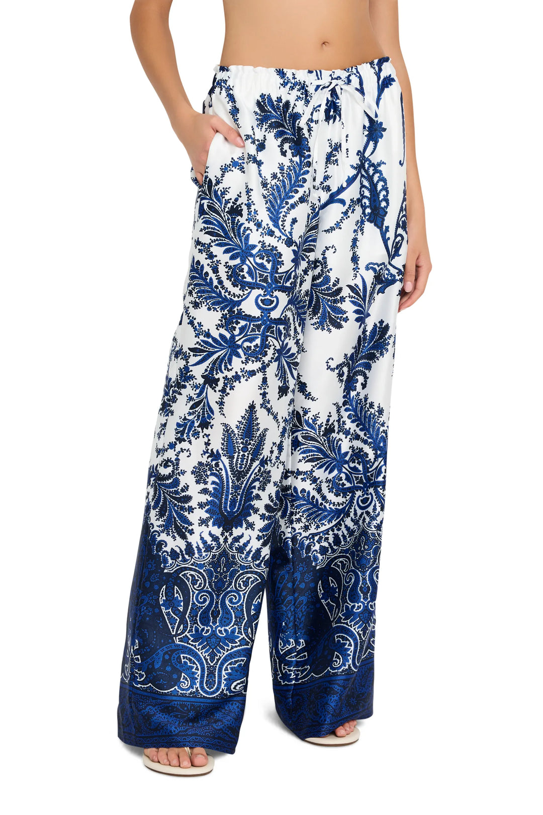 Wide-leg twill pants with elastic waist and paisley print, fluid silhouette. Front view on model.