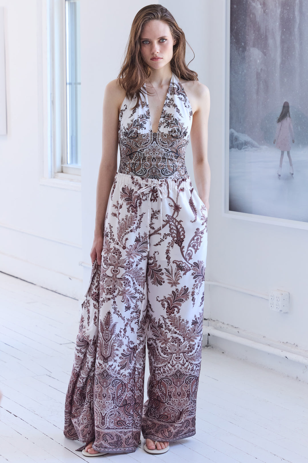 Wide-leg twill pants with structured waist and tailored seams. Editorial setting.