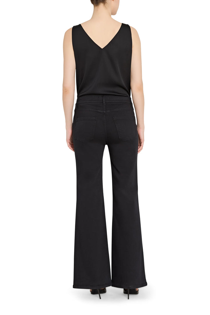 Person wearing a black sleeveless top and black flared pants on a white background