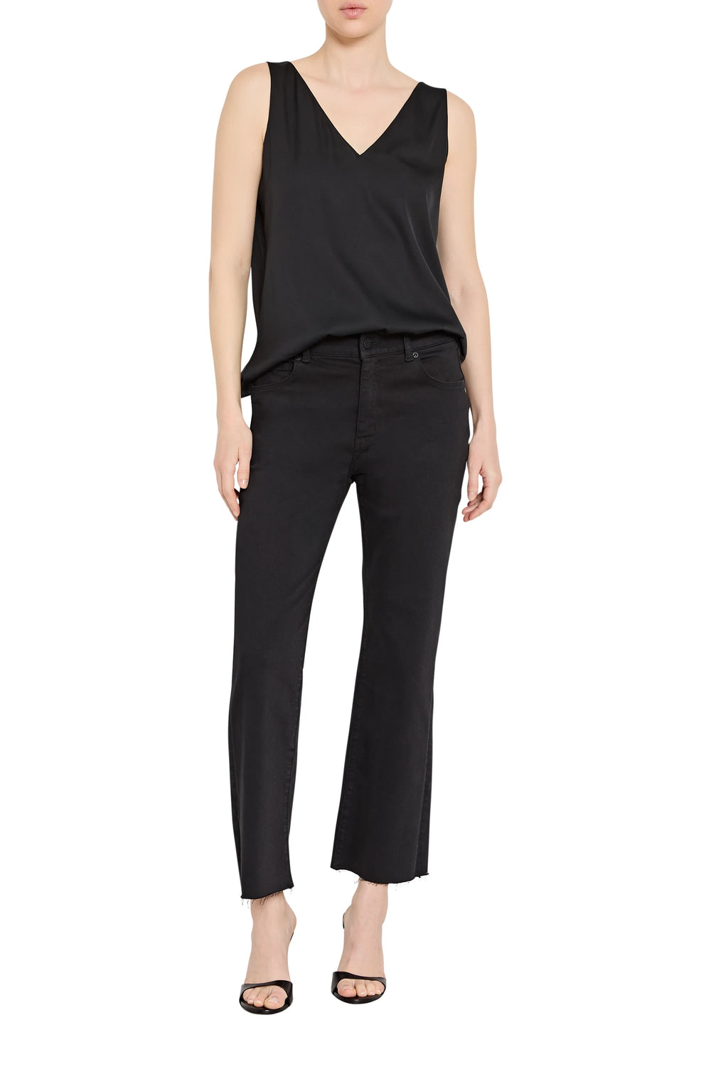 Person wearing a black sleeveless top and black pants on a white background