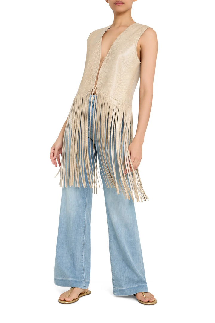 Sleeveless leather vest with long fringe trim, structured fit and open front. Front view on model.