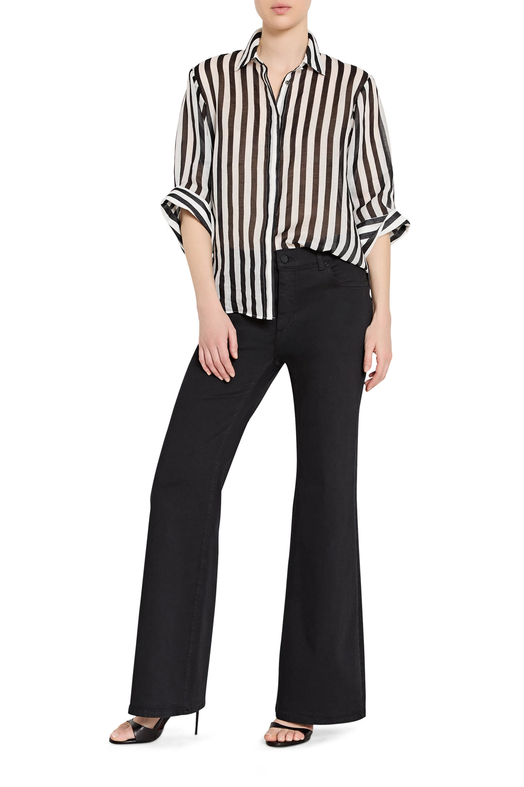 Person wearing a black and white striped shirt with black pants on a white background