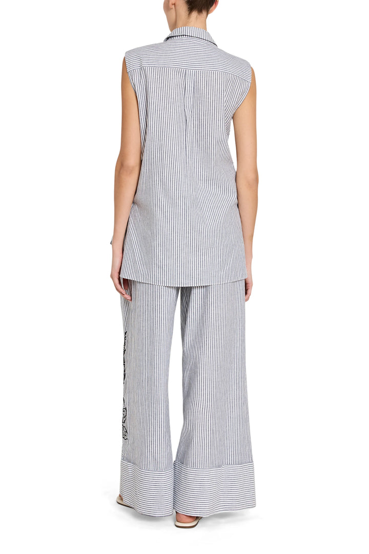 Woman wearing a sleeveless striped shirt and wide-leg pants on a white background