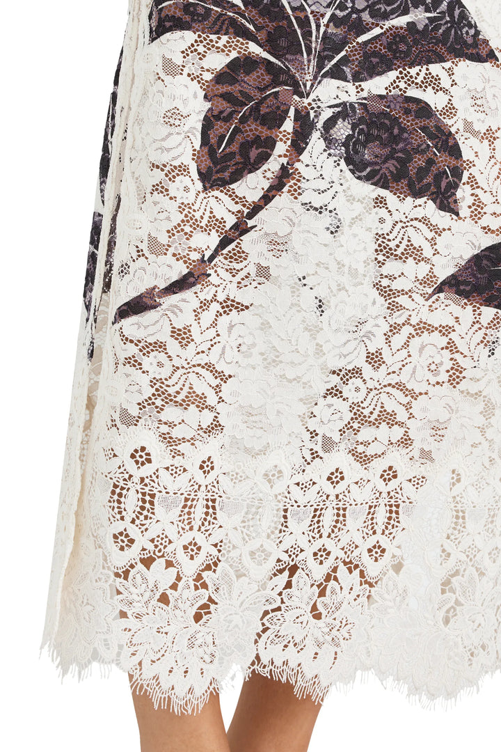 Maxi dress with fitted bodice, flared skirt, white lace overlay and dark botanical print. Front view on white.