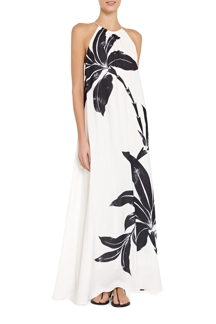 Woman wearing a white dress with black floral patterns on a white background