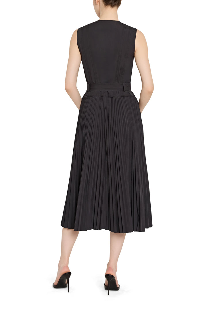 Black pleated dress worn by a model on a white background