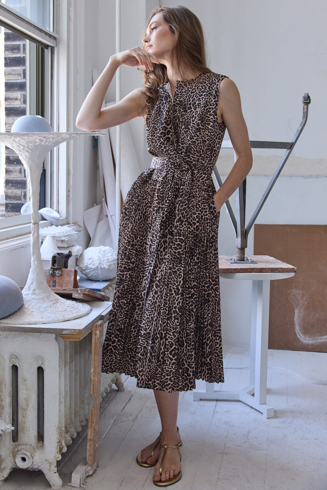 Leopard Dress with fitted bodice, midi silhouette, puff sleeves; side view on model in editorial setting.