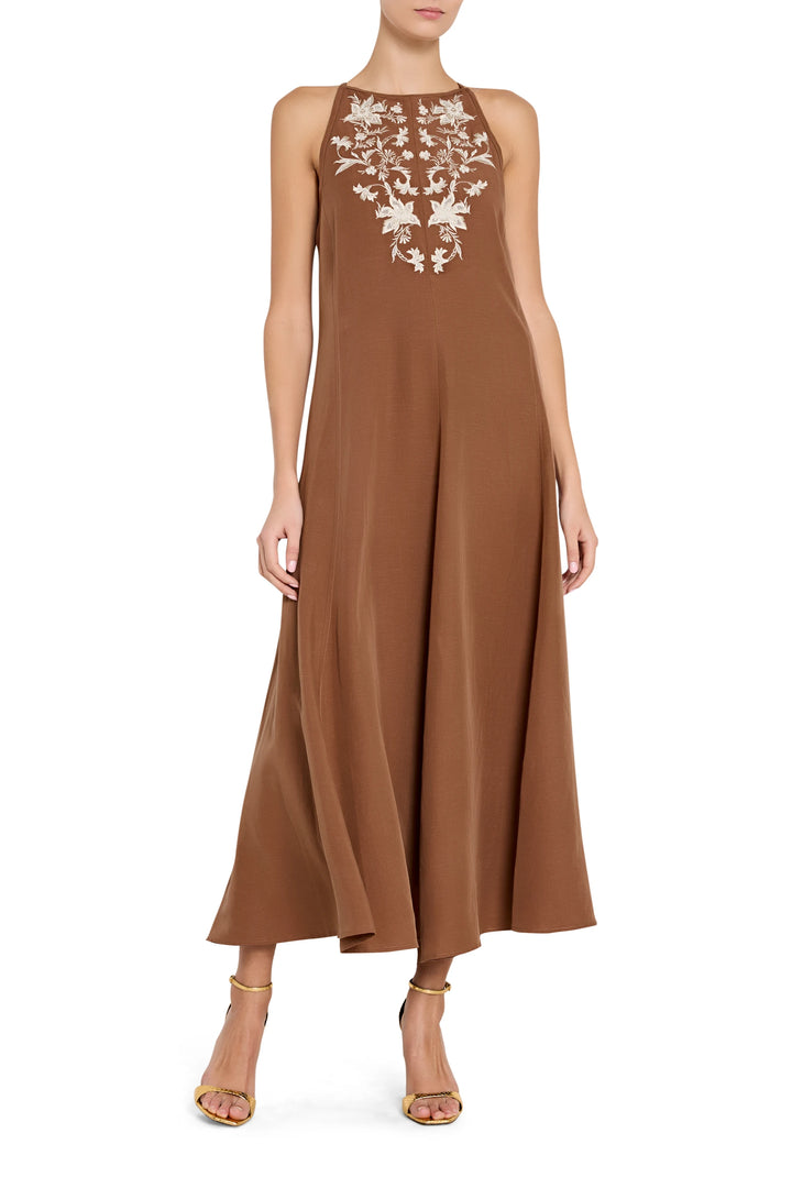 Maxi dress with fitted bodice, flowing skirt, front embroidery detail; sleeveless, adjustable straps; front view on model.