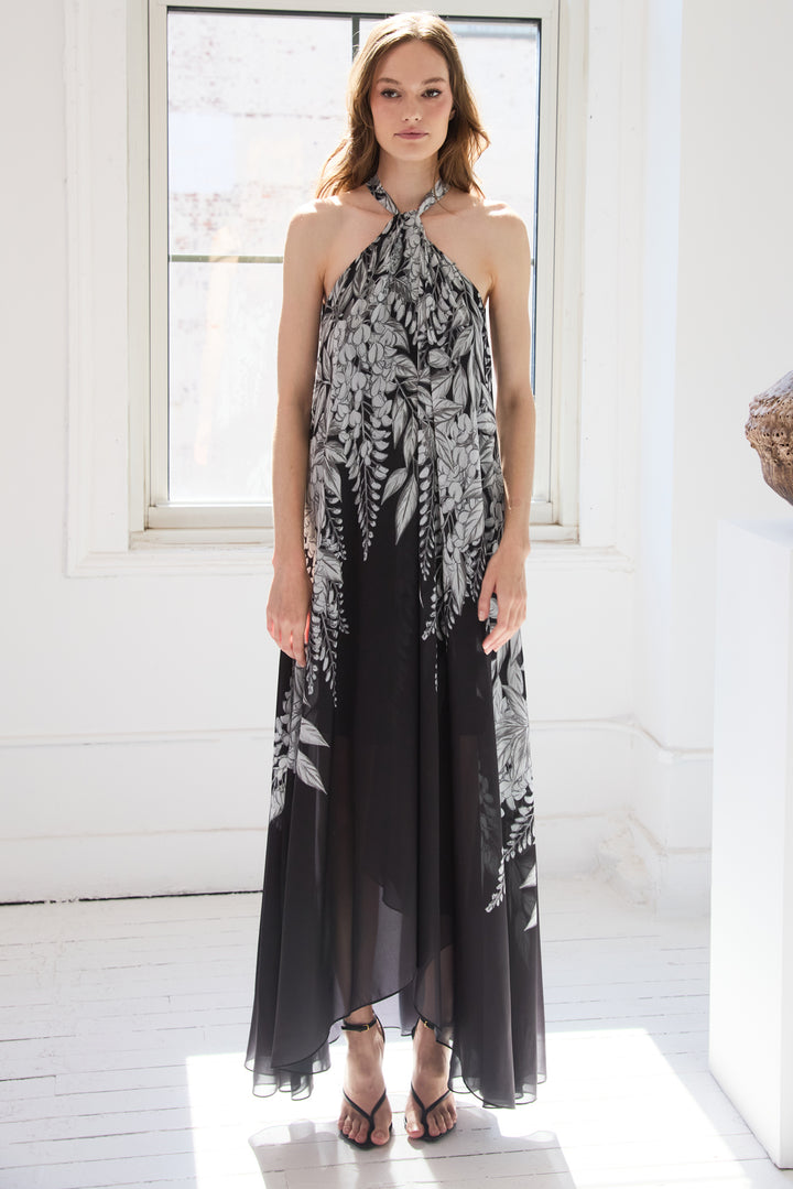 Sleeveless maxi dress with halter neckline, draped silhouette, vine print. Front view on model.