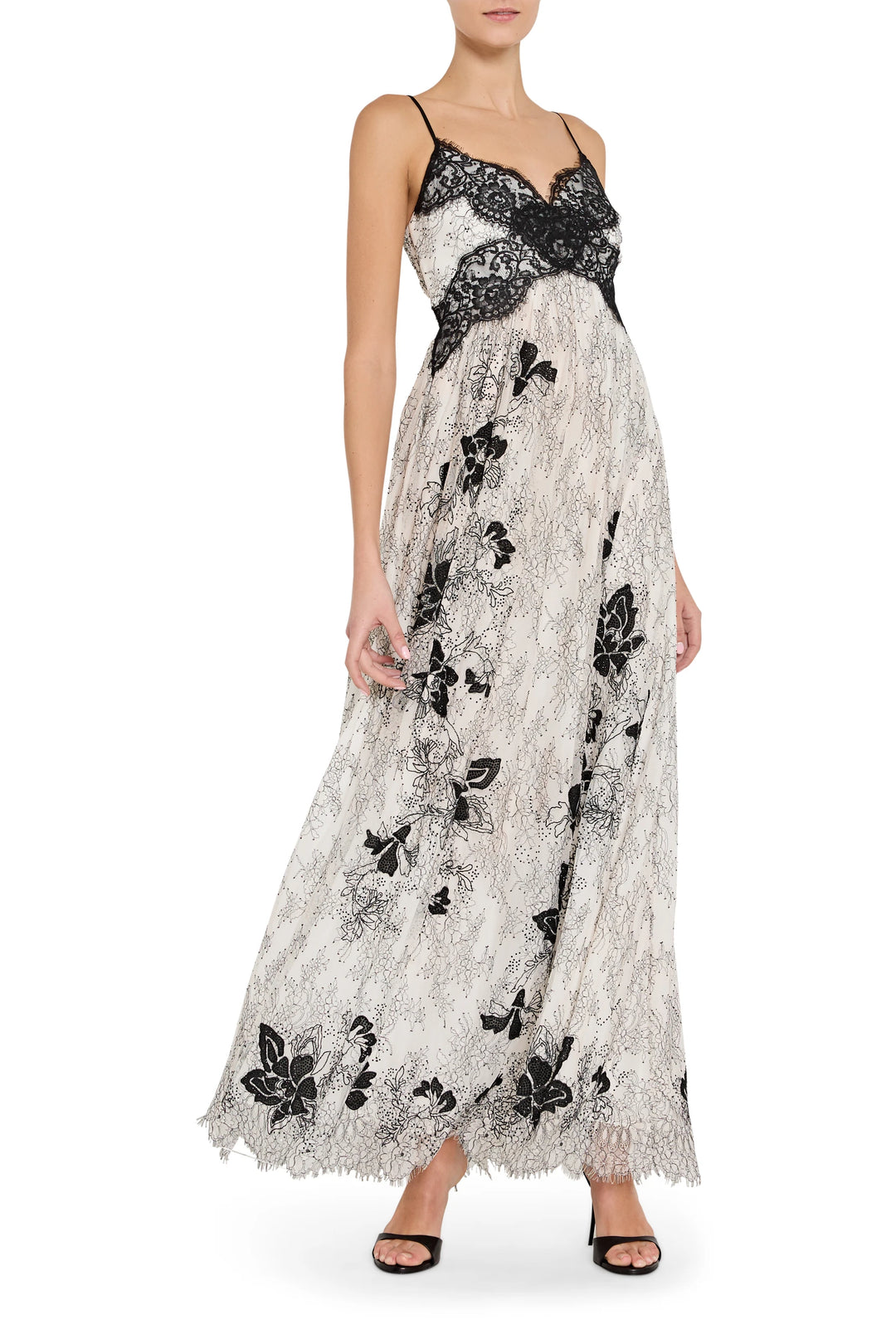 Woman wearing a black and white lace dress with butterfly patterns on a white background