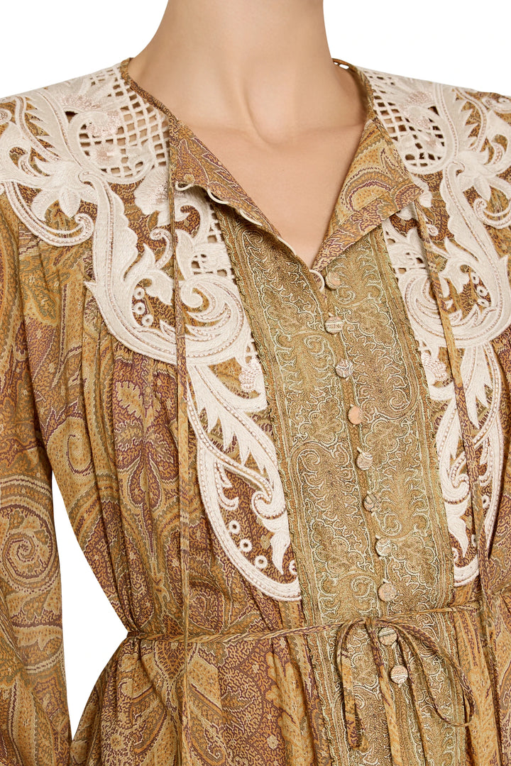 Detail of paisley print cotton dress with hand embroidery and white lace trim at shoulders and neckline, detail view.