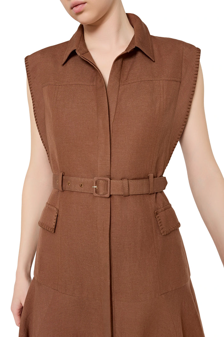 Sleeveless linen dress with belted waist, collar, front patch pockets; straight midi silhouette. Front view on model.