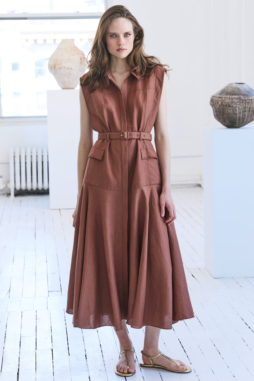 Linen midi dress with belted waist, relaxed silhouette, and short sleeves; front view on model.