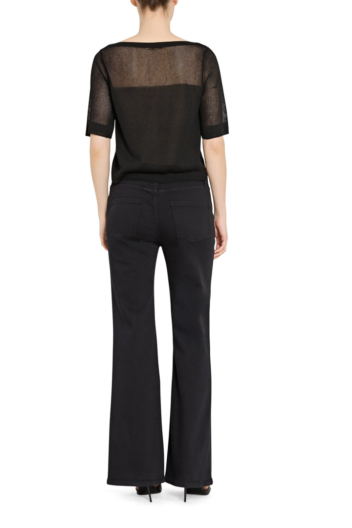 Black outfit with sheer top and flared pants on a white background