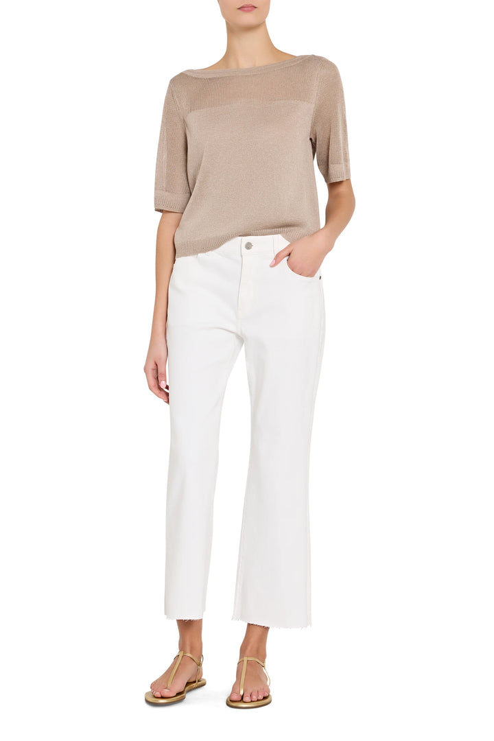 Woman wearing a beige top and white pants on a white background