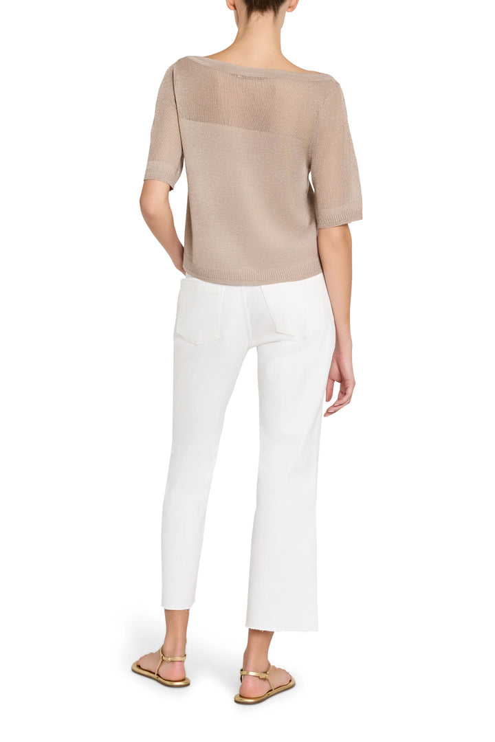 Woman wearing a beige top and white pants on a white background