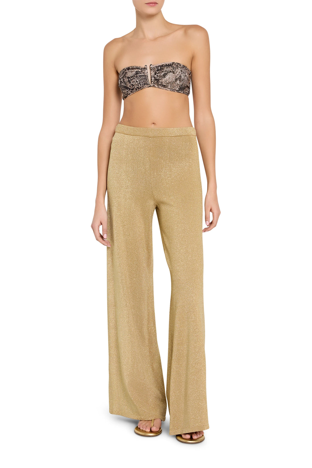 Woman wearing a strapless lace top and beige wide-leg pants on a white background