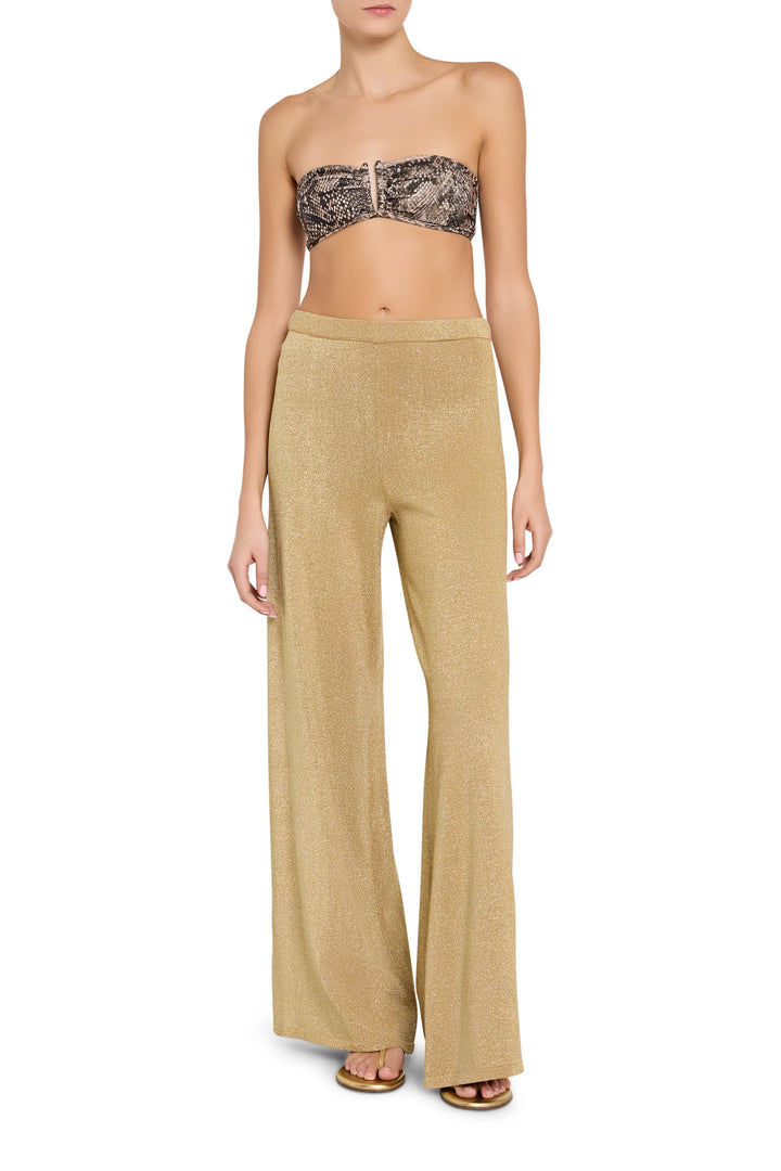 Woman wearing a strapless lace top and beige wide-leg pants on a white background