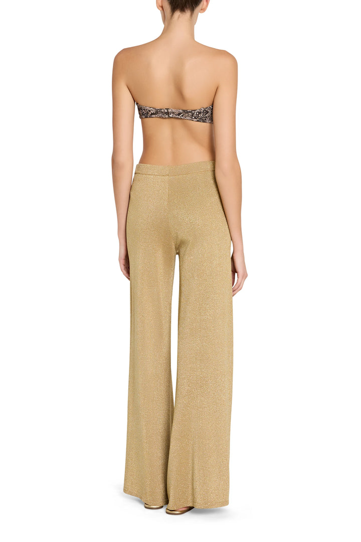 Woman wearing a strapless top and beige wide-leg pants on a white background