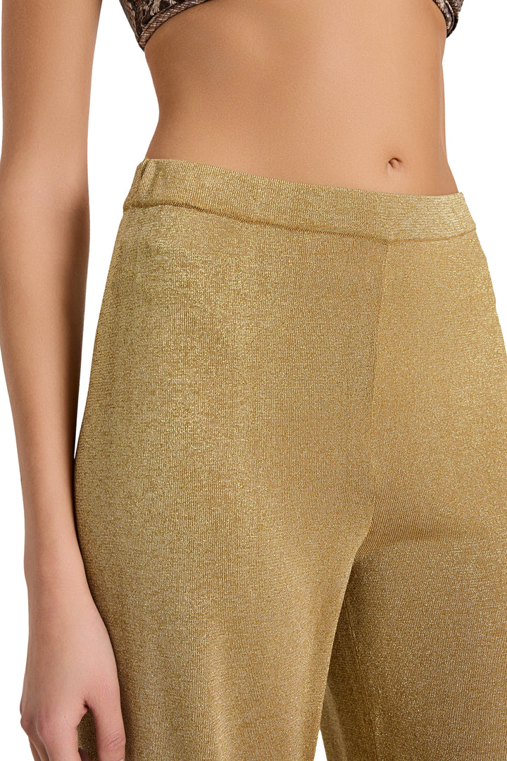 Gold leggings worn by a person on a white background