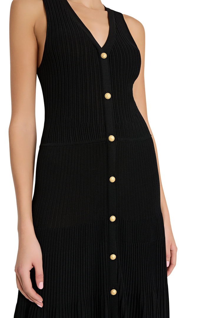 Black dress with gold buttons on a white background